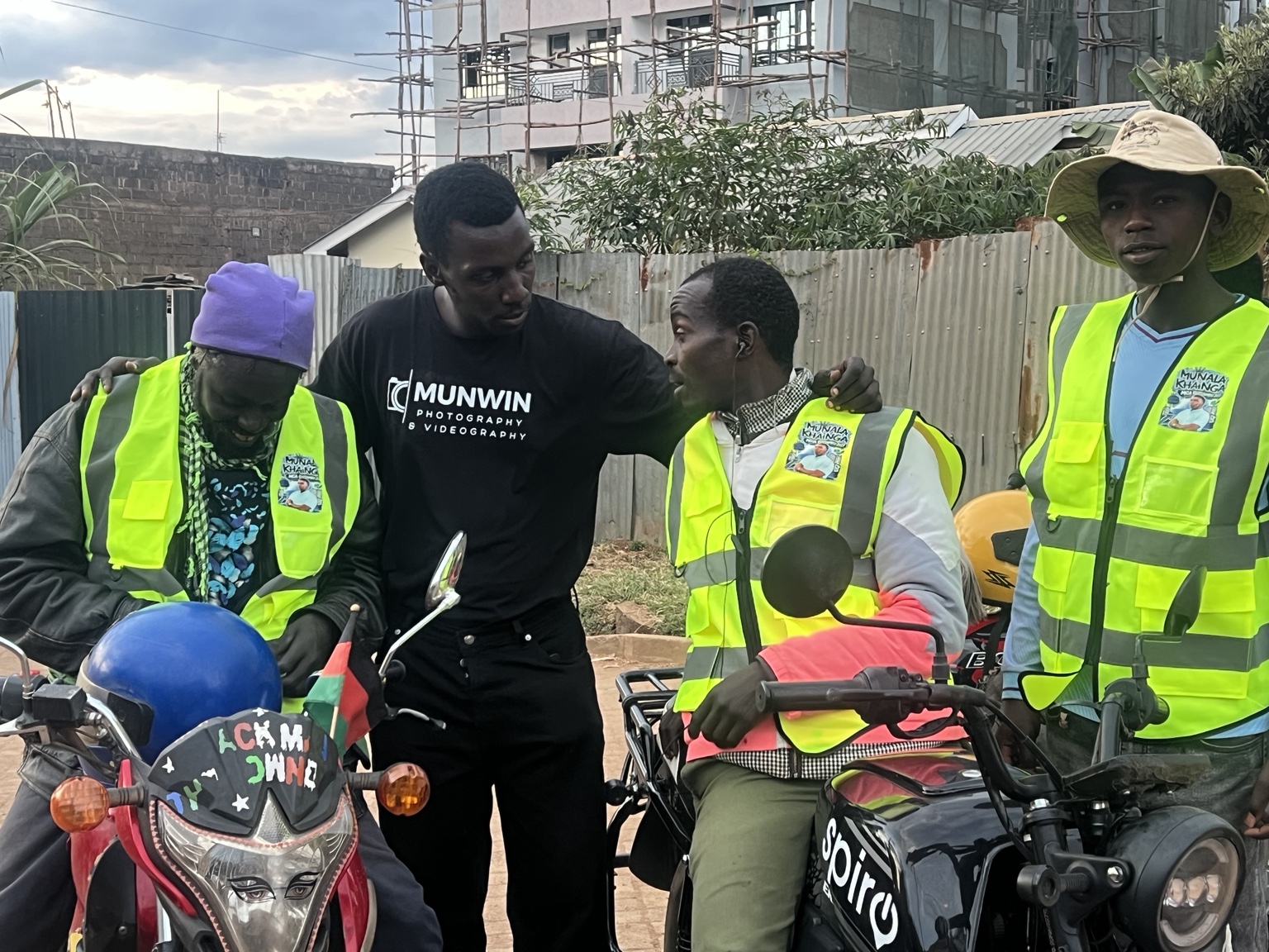 Munala speaking with boda boda riders wearing reflective safety jackets