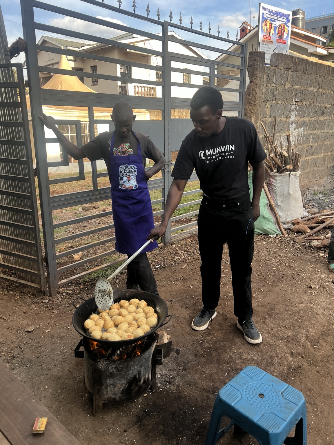 Munala joining a local food trader as he fries food for customers